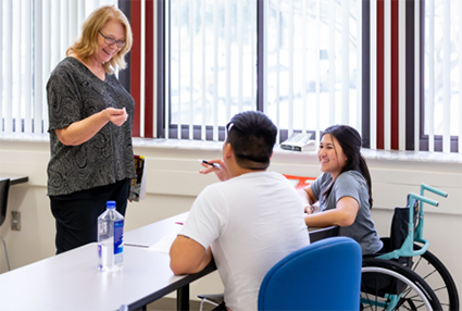 A professor is talking to two Disability Support Students